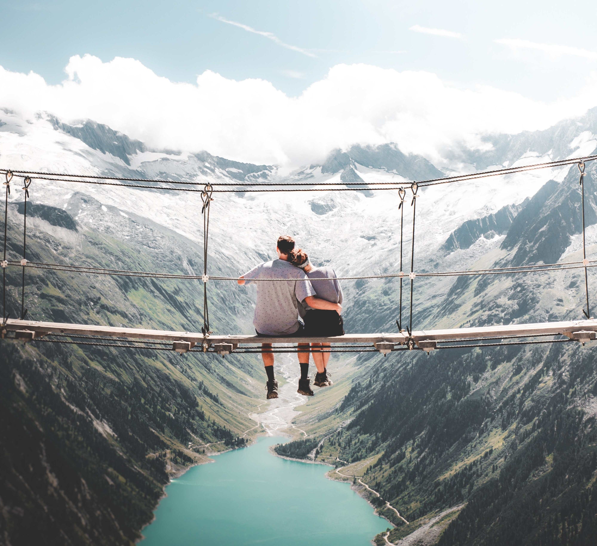 couple sitting on a bridge looking at the mountains thinking about supplements
