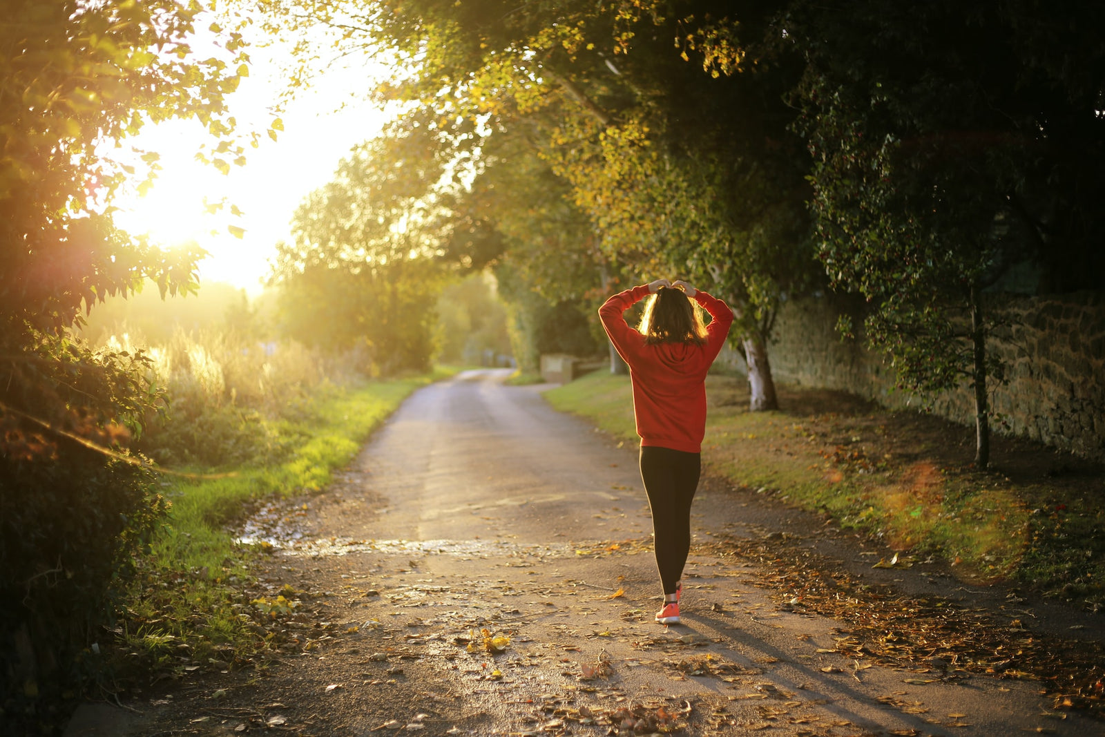 woman in woods looking towards the sun getting vitamin d