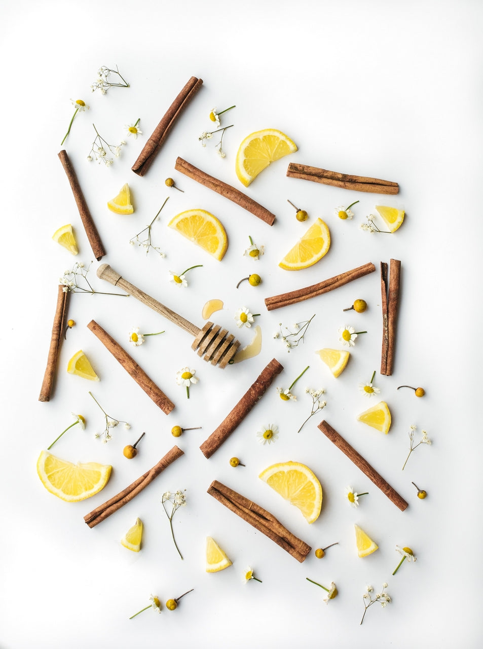 benefits of cinnamon sticks with lemon slices, flowers, and honey stirrer 