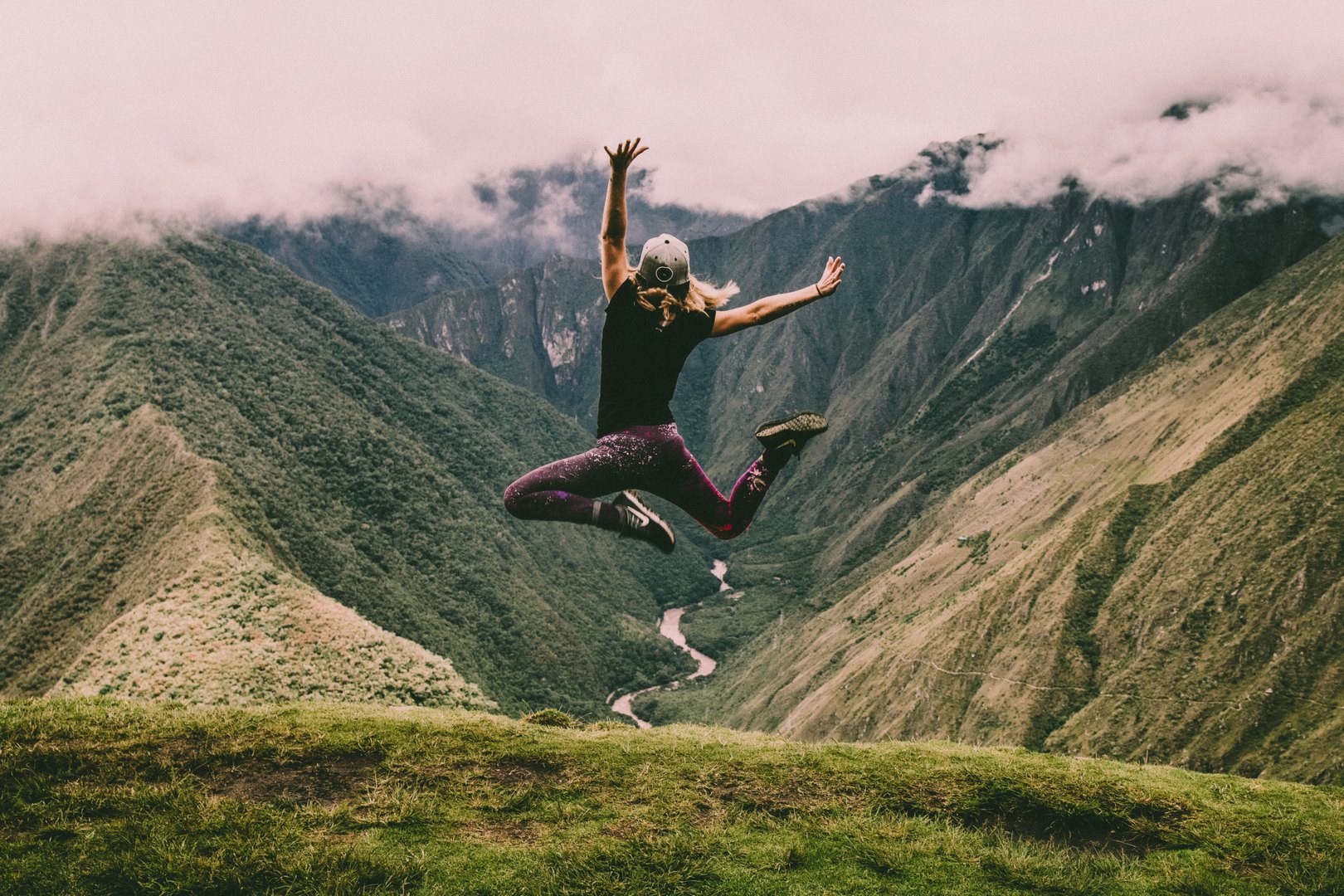 woman jumping on top of mountain habits