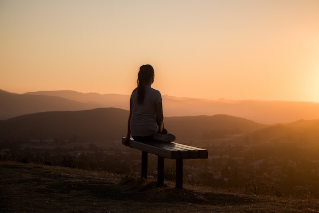 woman sitting on a bench and enjoying sunset health myths