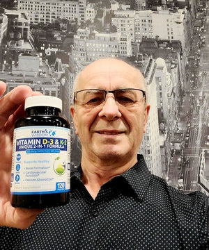 man holding a bottle of earth's wisdom vitamin d3 and k2 formula