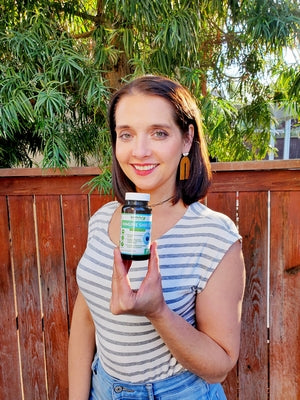 woman holding a bottle of earth's wisdom immune support formula